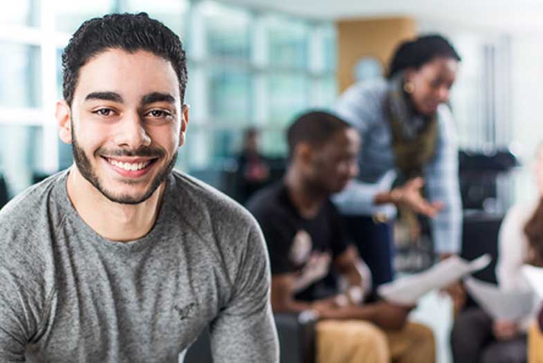 Un étudiant prend place dans une salle de classe.